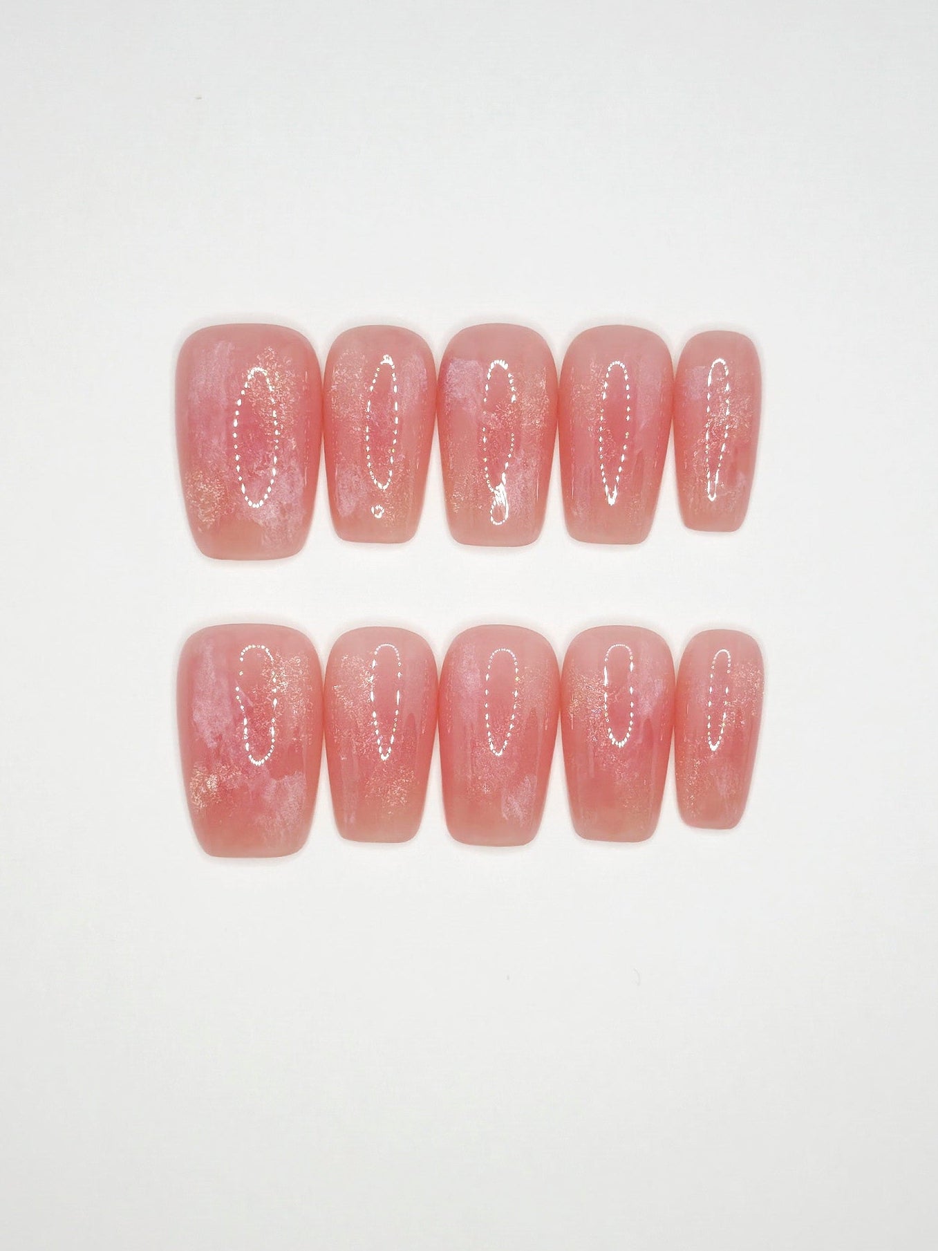 Set of pink press-on nails with decorative cutouts on a white background