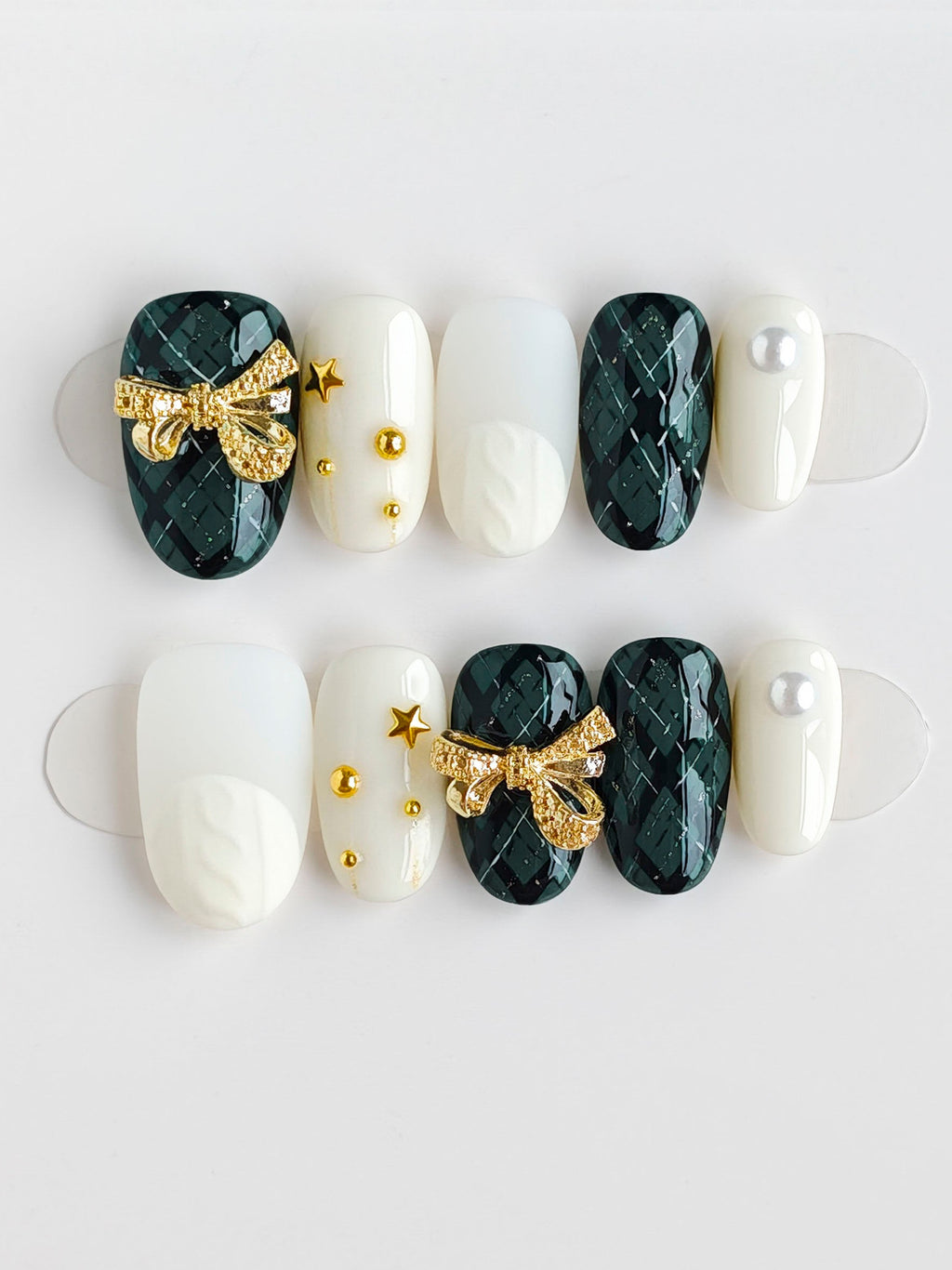 Nail art design with green marble, gold bows, and pearls on a white background