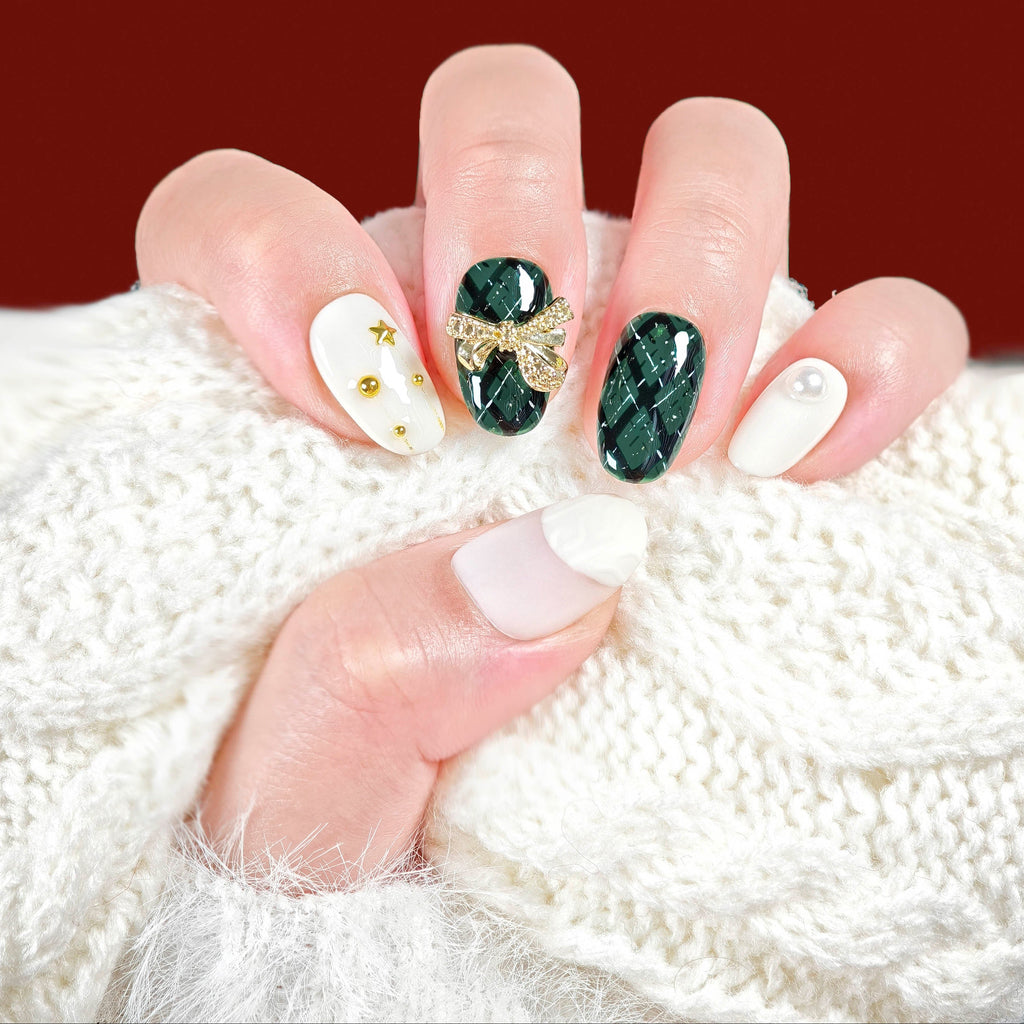 Hand with decorated nails holding a white knitted fabric, with 'Merry Christmas' text on a red background.